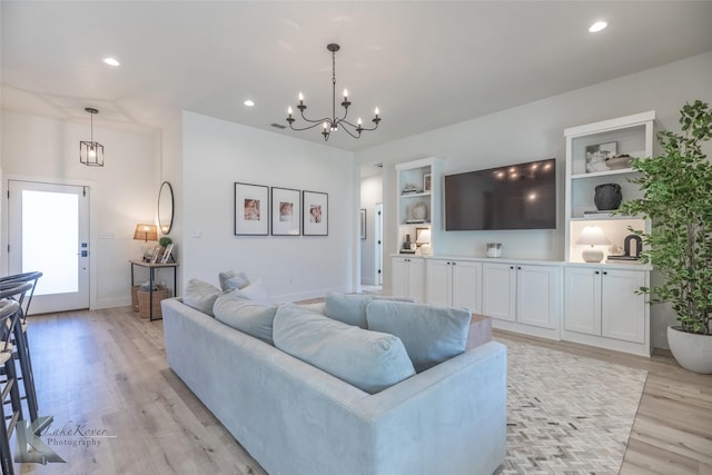 living room featuring a chandelier, baseboards, light wood-style flooring, and recessed lighting