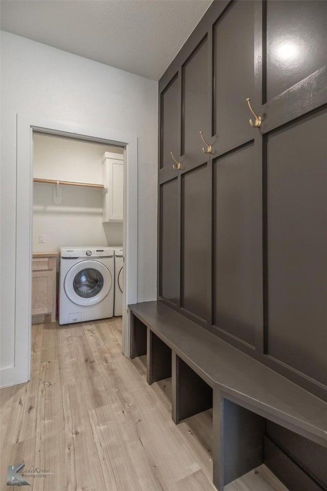 mudroom with light wood-type flooring and washing machine and dryer