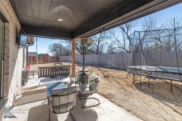 view of patio / terrace with a trampoline and a fenced backyard