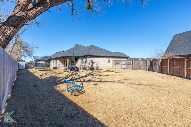 view of yard with a fenced backyard and a trampoline