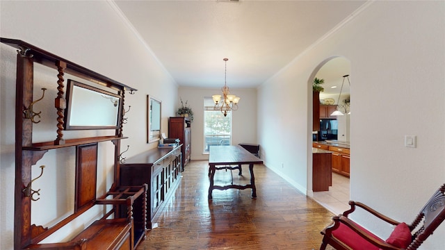 dining area featuring a chandelier, light wood finished floors, arched walkways, and ornamental molding