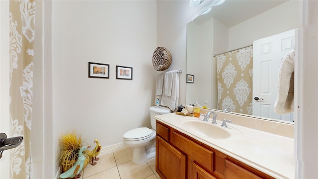 bathroom with tile patterned flooring, baseboards, vanity, and toilet