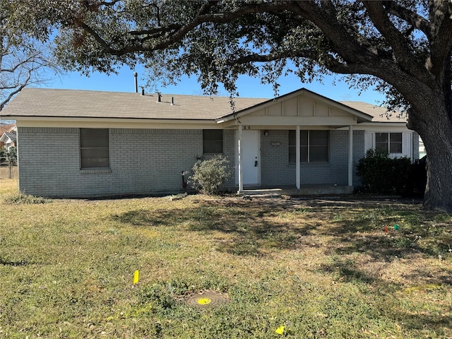 ranch-style house with a front lawn, board and batten siding, and brick siding