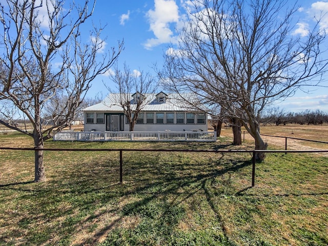 view of front facade featuring a fenced front yard, a front lawn, and metal roof