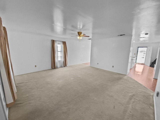 spare room with a ceiling fan, visible vents, and light colored carpet