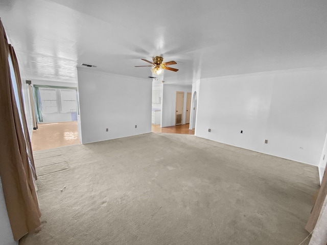 unfurnished living room featuring ornamental molding, light colored carpet, ceiling fan, and visible vents