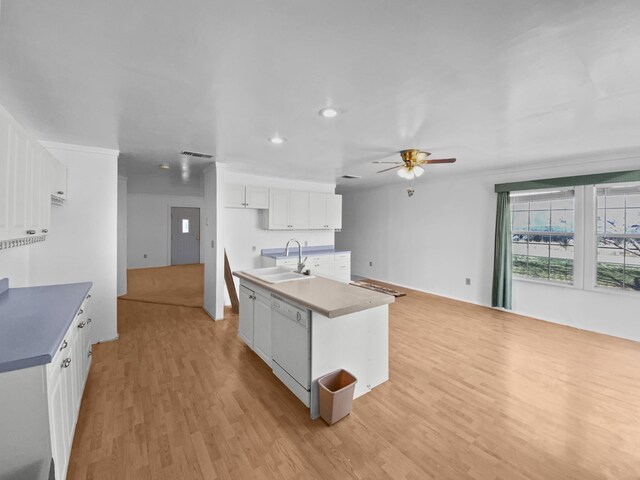 kitchen with dishwasher, an island with sink, open floor plan, white cabinetry, and a sink