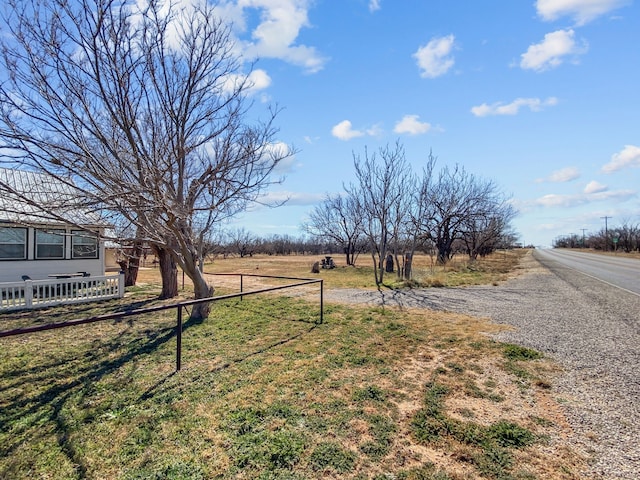 view of yard featuring a rural view and fence