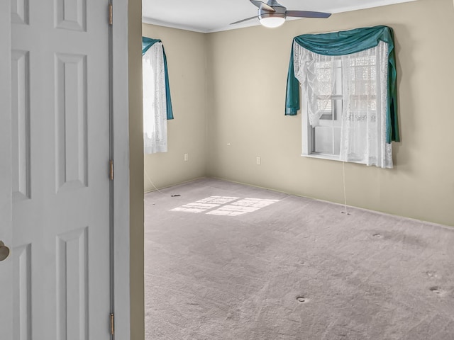 unfurnished room with a ceiling fan and light colored carpet