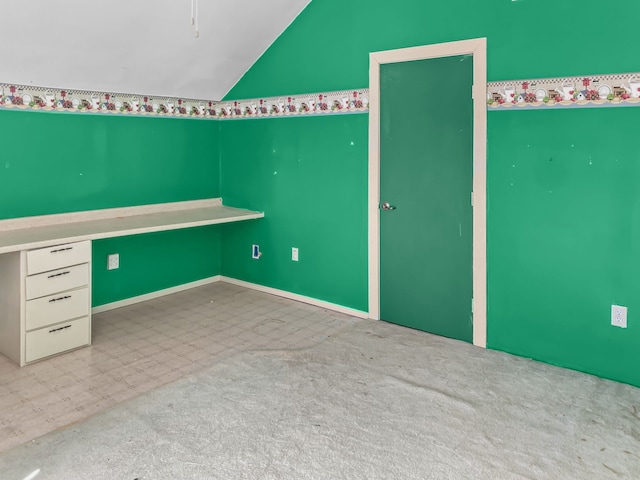 unfurnished bedroom with vaulted ceiling, light floors, and light colored carpet