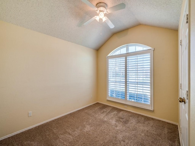 carpeted empty room with ceiling fan, vaulted ceiling, and a textured ceiling