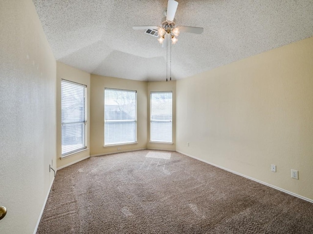 empty room featuring visible vents, baseboards, ceiling fan, carpet floors, and a textured ceiling