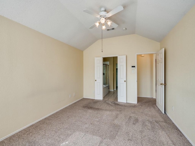 unfurnished bedroom featuring visible vents, baseboards, carpet, lofted ceiling, and a ceiling fan