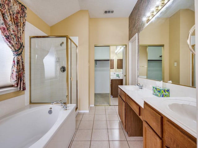 full bathroom featuring a garden tub, double vanity, a sink, a shower stall, and tile patterned floors