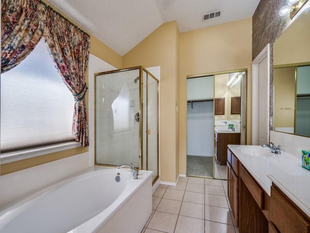 bathroom featuring tile patterned flooring, visible vents, a stall shower, a bath, and vanity