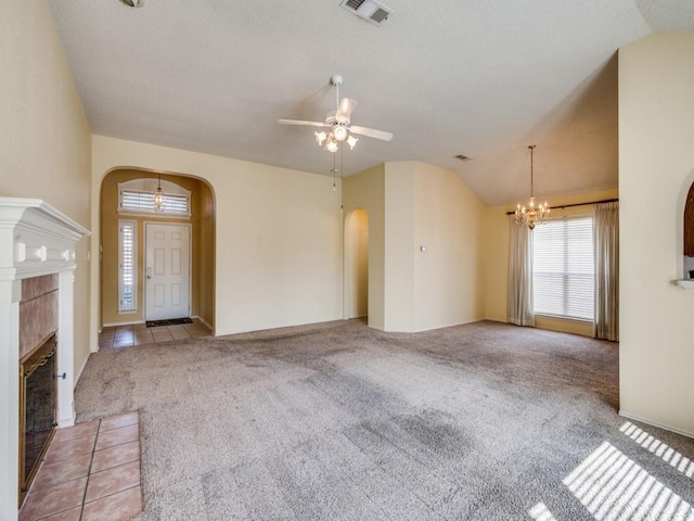 unfurnished living room featuring vaulted ceiling, visible vents, arched walkways, and carpet floors