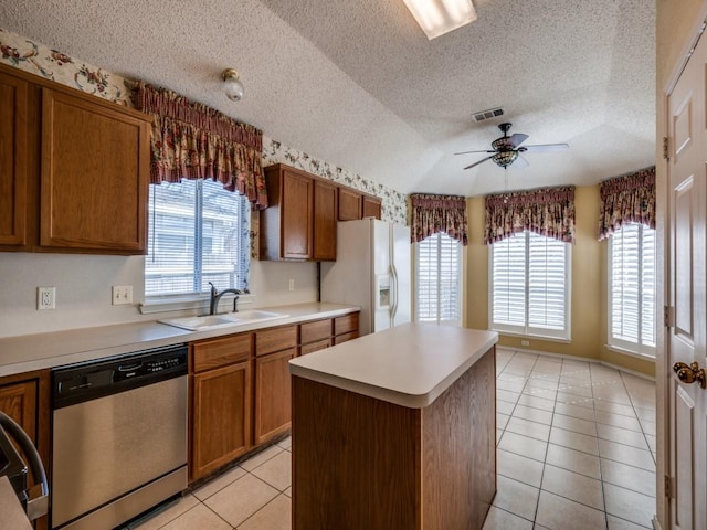 kitchen featuring visible vents, dishwasher, white refrigerator with ice dispenser, brown cabinetry, and a ceiling fan