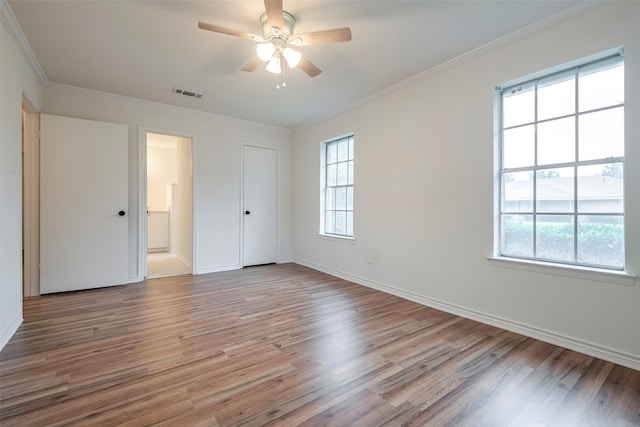 unfurnished bedroom with baseboards, light wood-style floors, visible vents, and crown molding