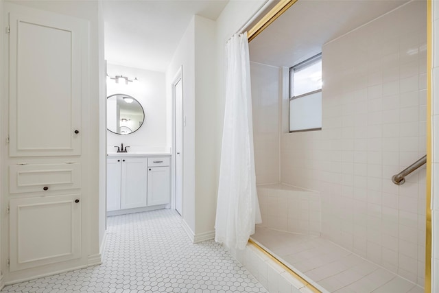 bathroom with a stall shower, vanity, and baseboards