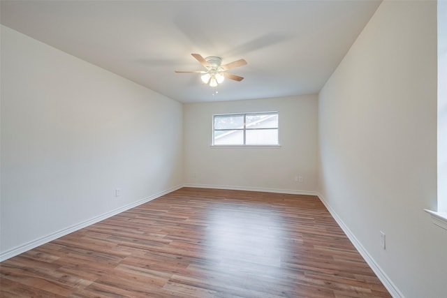 empty room featuring ceiling fan, light wood-style flooring, and baseboards