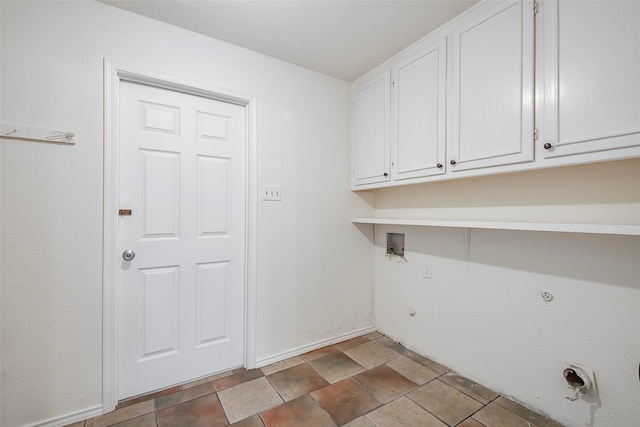 clothes washing area featuring cabinet space, baseboards, gas dryer hookup, hookup for a washing machine, and stone finish flooring