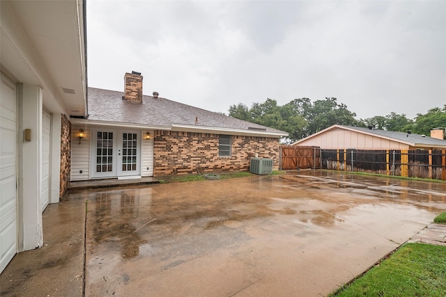 view of patio with fence, central AC unit, and french doors