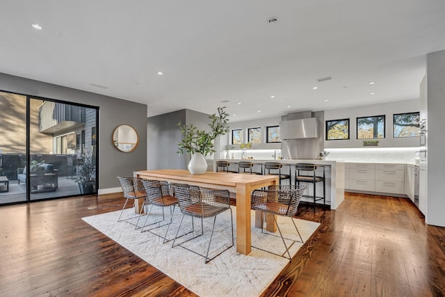 dining area featuring baseboards, wood finished floors, and recessed lighting