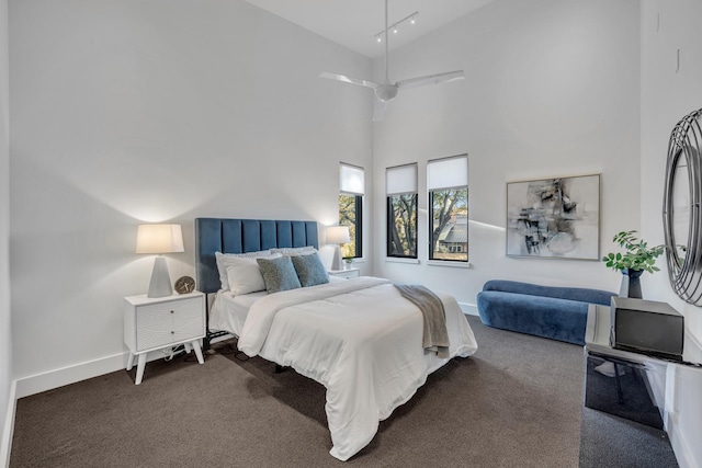 carpeted bedroom with high vaulted ceiling and baseboards