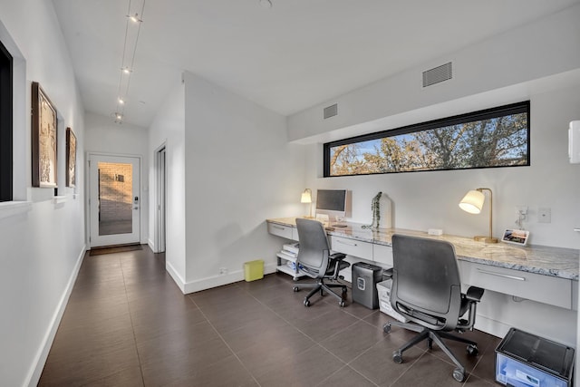 office space with visible vents, vaulted ceiling, and baseboards