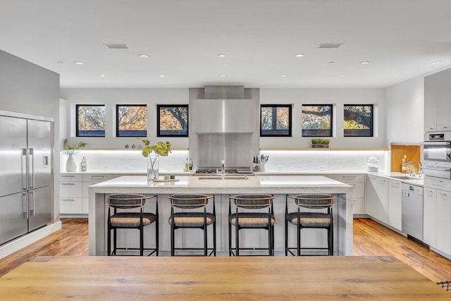 kitchen with a center island with sink, a breakfast bar area, and light countertops