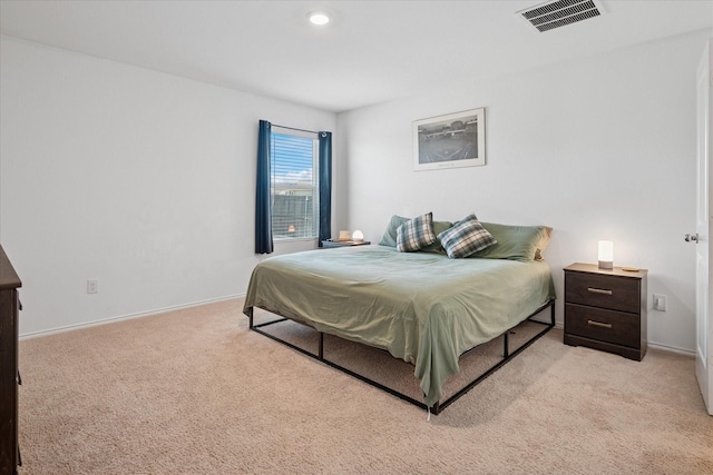 bedroom featuring baseboards, visible vents, and light colored carpet