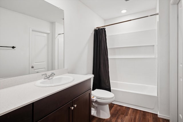 bathroom featuring toilet, shower / tub combo, wood finished floors, and vanity