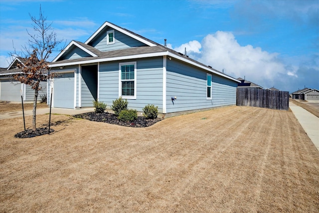 exterior space featuring driveway, a garage, and fence