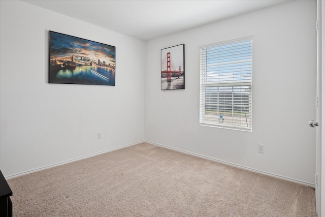 carpeted empty room with a wealth of natural light and baseboards