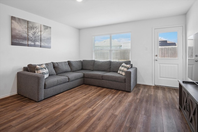 living room featuring dark wood-type flooring and baseboards