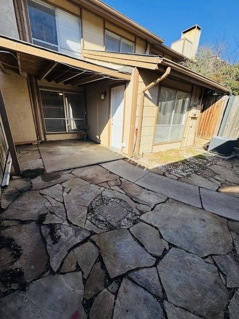 exterior space with a chimney, fence, and a patio