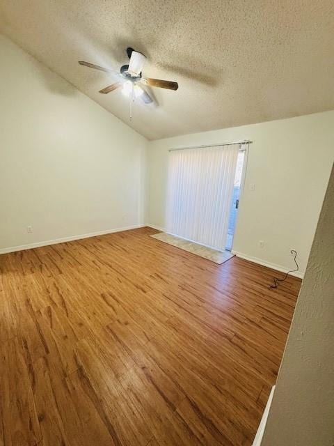 spare room featuring a textured ceiling, wood finished floors, a ceiling fan, and baseboards