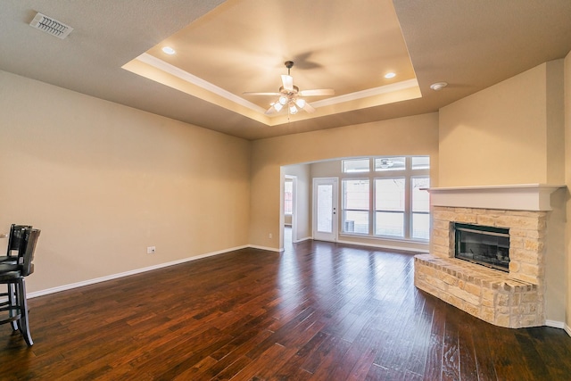 living area featuring a raised ceiling, dark wood-style floors, visible vents, and ceiling fan