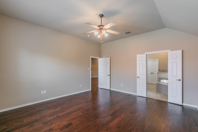 unfurnished bedroom featuring visible vents, dark wood-style floors, baseboards, ceiling fan, and vaulted ceiling