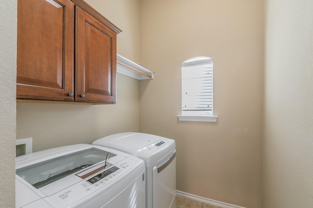 laundry room with washing machine and clothes dryer, cabinet space, and baseboards