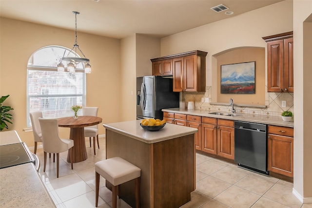 kitchen featuring visible vents, a sink, stainless steel fridge, light countertops, and dishwasher