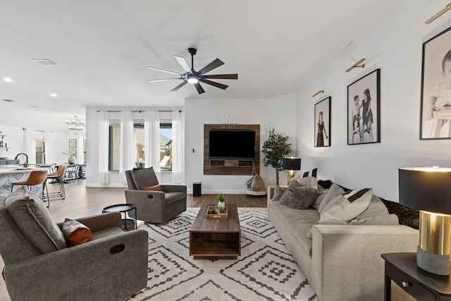 living room featuring visible vents, wood finished floors, baseboards, recessed lighting, and ceiling fan with notable chandelier