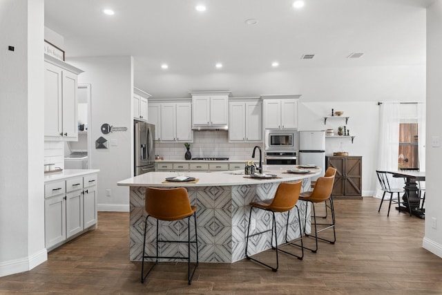 kitchen featuring light countertops, appliances with stainless steel finishes, a breakfast bar area, and a sink