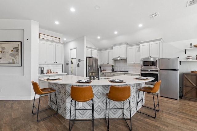 kitchen featuring appliances with stainless steel finishes, light countertops, visible vents, and a sink