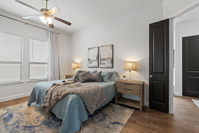 bedroom with ceiling fan, baseboards, and wood finished floors