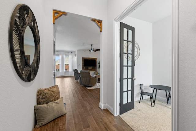 corridor with baseboards and dark wood finished floors