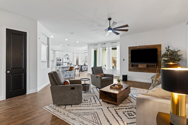 living area featuring baseboards, a ceiling fan, wood finished floors, and recessed lighting