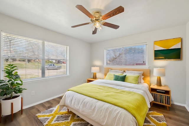 bedroom with ceiling fan, baseboards, and dark wood finished floors