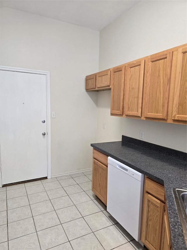 kitchen featuring built in desk, brown cabinetry, white dishwasher, and light tile patterned flooring