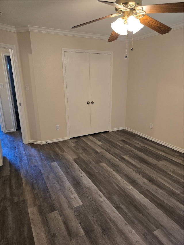 unfurnished bedroom with ceiling fan, baseboards, a closet, dark wood finished floors, and crown molding